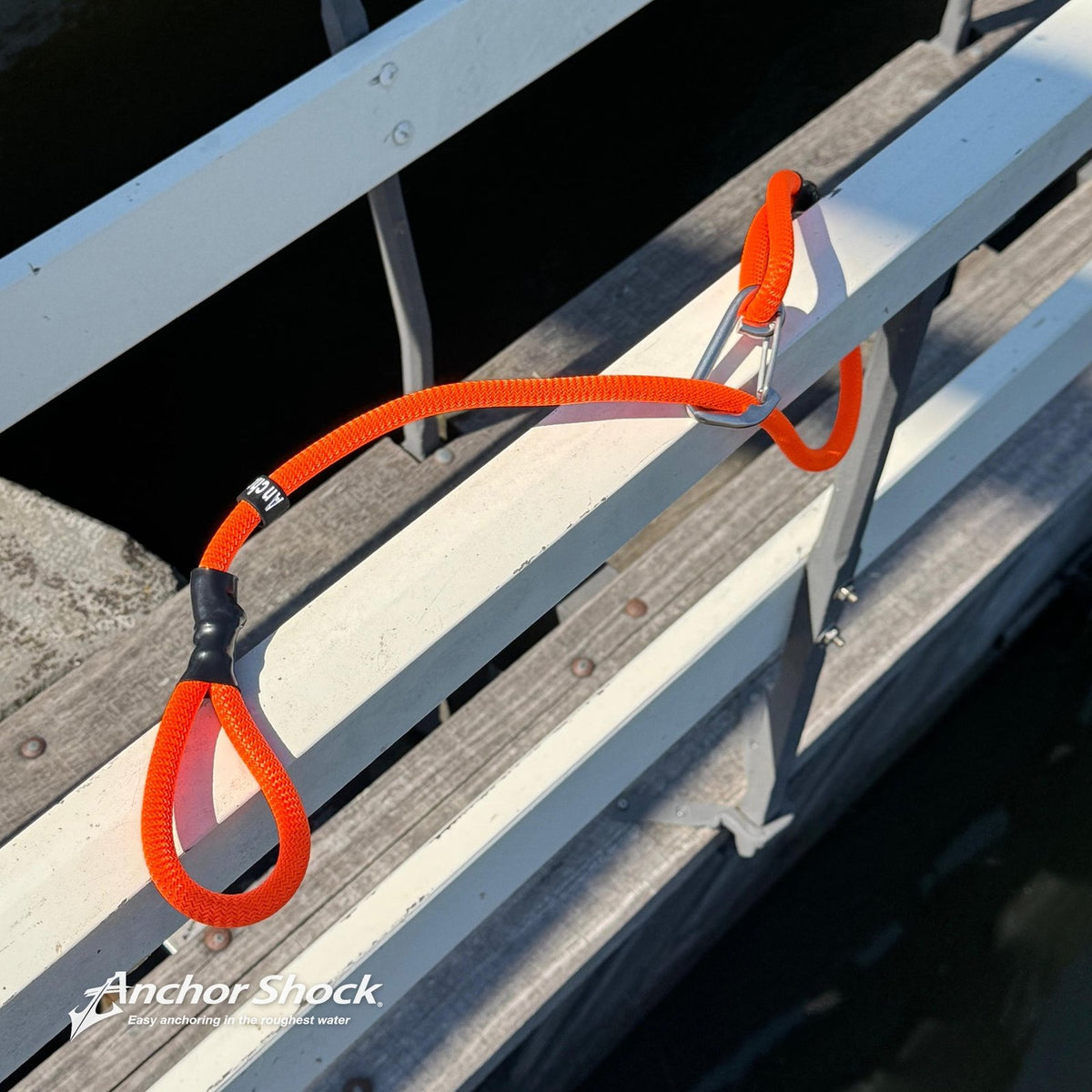 Dock Shock oranje met karabijnhaak aan de reling van een steiger